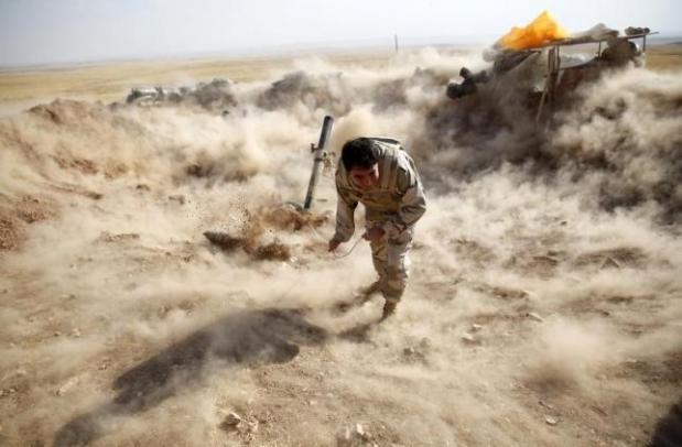 A Kurdish Peshmerga fighter launches mortar shells towards Zummar, controlled by Islamic State, near Mosul